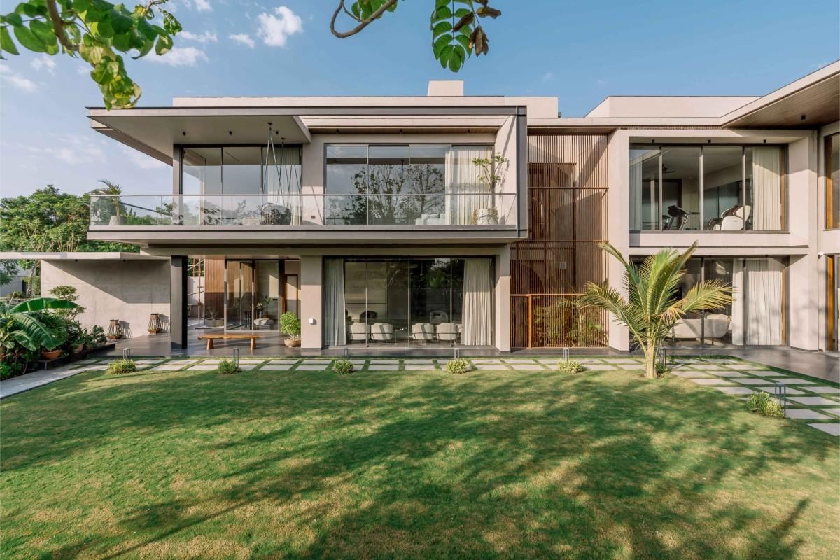 Contemporary two-storey home with full-height glazing opening onto a lawn
